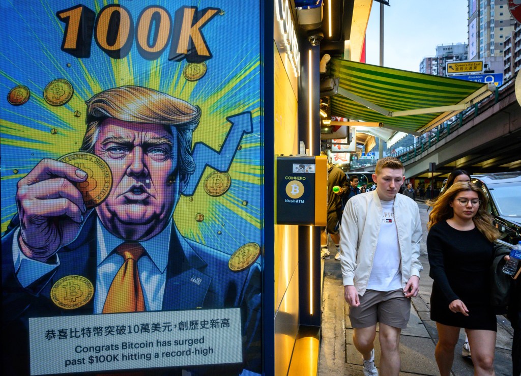 The Cryptocurrency Exchange Office in Hong Kong with a screen involving President Trump holding Cryptocurrency coins.